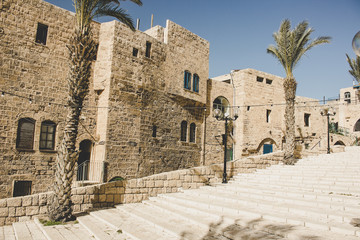 ancient Jewish Jaffa city street with old buildings and palm trees along stairs alley way
