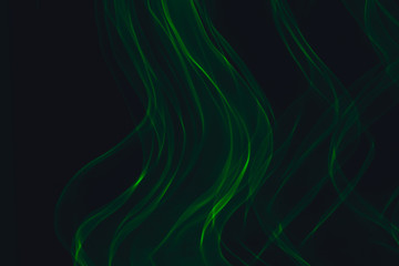 Green neon lines. Abstract black background. Neon lights texture.