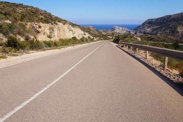 Empty clean smooth highway road close up on a sunny summer tropical island near the mountains and the sea for background.