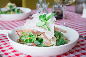 plate with fresh italian salad with ham and vegetables