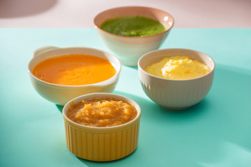 Bowls with baby food. Various bowls of fruit and vegetable puree with ingredients for cooking