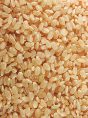 Top view of brown rice (also called hulled rice, unpolished rice,husked rice).   Nutrition rich in protein, lipids, fiber, vitamin B1. Asian, Chinese food background. Health, agriculture concept.