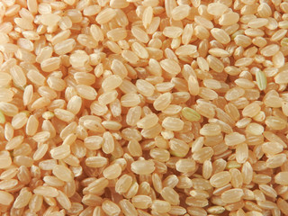 Top view of brown rice (also called hulled rice, unpolished rice,husked rice).   Nutrition rich in protein, lipids, fiber, vitamin B1. Asian, Chinese food background. Health, agriculture concept.