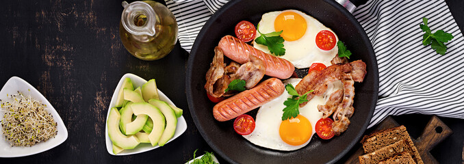 English breakfast - fried egg, tomatoes, sausage and bacon. Banner. Top view