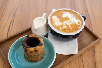 Hot latte with cookies on a wooden table