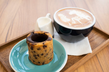 Hot latte with cookies on a wooden table