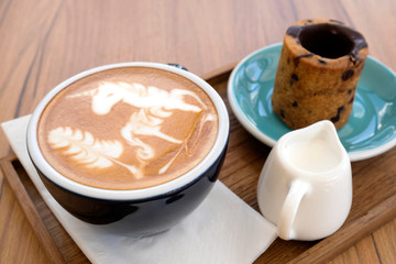 Hot latte with cookies on a wooden table