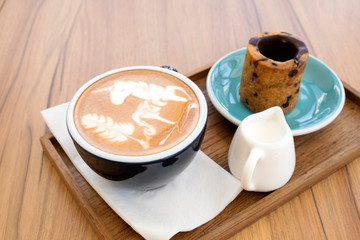 Hot latte with cookies on a wooden table