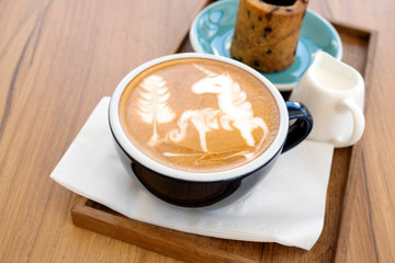 Hot latte with cookies on a wooden table