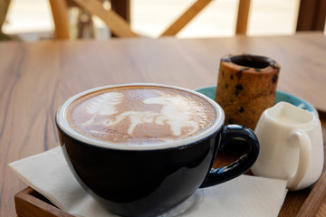 Hot latte with cookies on a wooden table