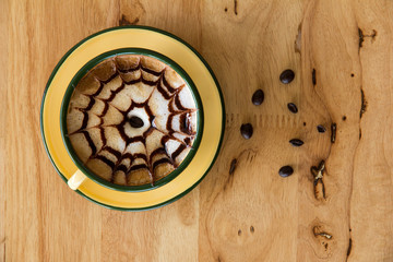 Cup of coffee is beautifully decorated, Coffee cup and coffee beans on a wooden table.