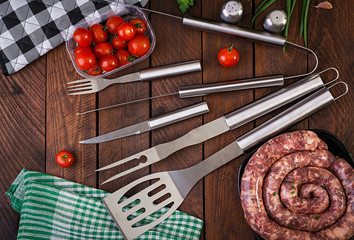 Barbecue Tools and sausage on wooden table. Flat lay, top view