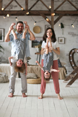 Fototapeta na wymiar Mom and dad hold children by feet upside down