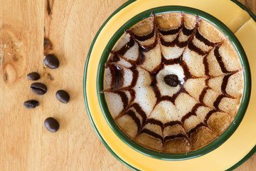 Cup of coffee is beautifully decorated, Coffee cup and coffee beans on a wooden table.