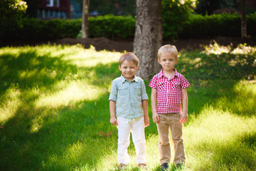 Fototapeta premium Two boys brothers playing and jumping outdoors in a park.