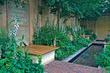 A small urban courtyard garden with a water feature and seating