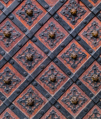 Ancient  gate with metal mounting and ironworks.  Beautiful decorative metal elements forged wrought iron gates.