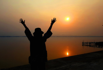 Fototapeta premium strong confidence woman open arms under the sunrise at seaside
