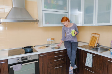 A woman prepares food using a tablet.