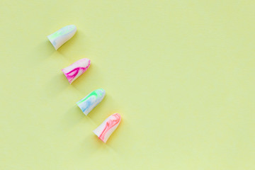 Earplugs on the yellow background. Good sleep and noise protection concept.