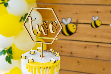 Bee, honey, honeycomb themed in wood tones baby shower party, newborn baby party, birthday party, "two" shaped cut pastry over wood cut font © ozencdeniz