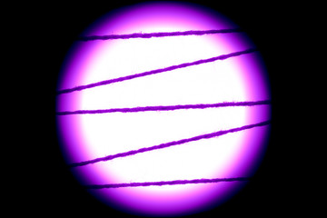 White and round spot of light with a purple halo on a black background. Minimalism. Black backdrop.