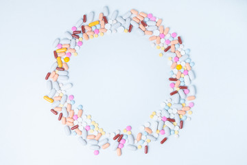 colored pills scattered in circle shape on white background with copy space for text. Opioid epidemic, painkillers and drug abuse concept