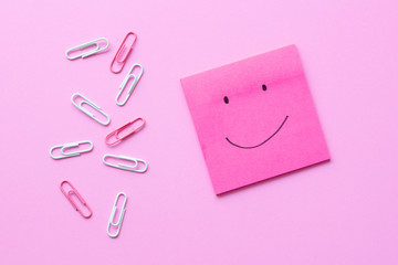 Smile on sticky note with paper clip
