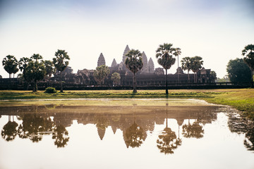 Angkor wat among palm trees reflected in water, Siem Reap, Kingdom of Cambodia.