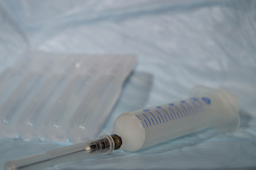 medical syringe with a needle on the background of drugs