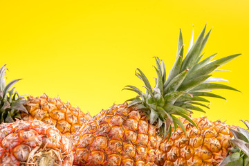 Beautiful fresh pineapple isolated on bright yellow background, summer seasonal fruit design idea pattern concept, copy space, close up