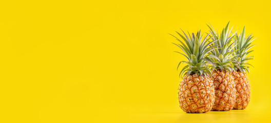 Beautiful fresh pineapple isolated on bright yellow background, summer seasonal fruit design idea...