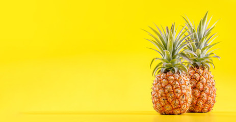 Beautiful fresh pineapple isolated on bright yellow background, summer seasonal fruit design idea pattern concept, copy space, close up