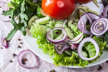 Fresh fragrant salad with tomatoes, cucumbers, onions, parsley, dill and lettuce leaves. Vegetarian...