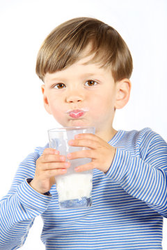 Ein dreij&auml;hriger Junge trinkt ein Glas Milch