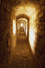 Old stony passage in ancient fortress with light in the end, Ukraine