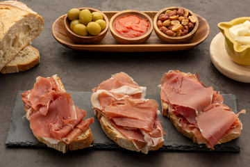 Spanish ham on bread with toasted peanuts olives and tomato fried