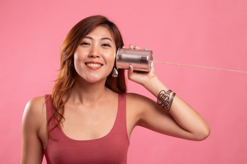 Young Asian woman with tin can phone.