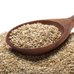 Raw organic superfood gluten free quinoa seeds in wooden spoon closeup on white background