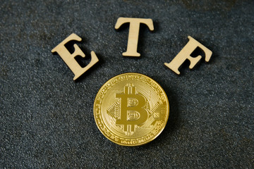 Bitcoin coin with ETF text on stone background