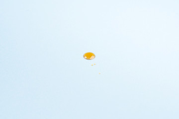 Drops of maple syrup on pastel blue background. Food abstract concept