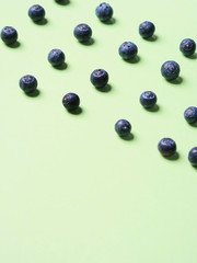 Pattern of fresh blueberries in on pastel green background. Healthy breakfast concept