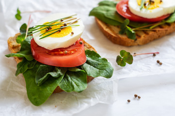 Toast of unleavened bread with tomato, spinach, egg and microgreen