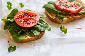 Toast of unleavened bread with tomato, spinach and microgreen