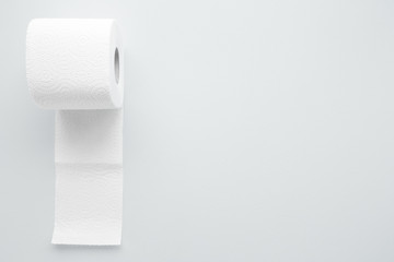 Soft, white toilet paper roll on light gray background. Hygiene concept. Empty place for text, object or logo. 