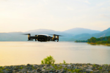 Silhouette drone flying over lake sunset