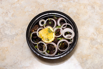 Slow Roasted Beef. Kerala style spicy beef dry fry served with raw onion and lemon in plastic disposable plate for delivery. South Indian famous dish. Top view.