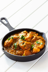 Close up traditional Indian butter chicken curry and lemon served with chapati bread on iron-cast.