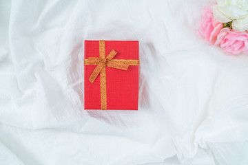 Red cardboard box for gifts and flower, isolated, white fabric texture background