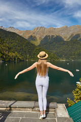 Fototapeta na wymiar Girl in a hat on the background of the mountains and lake